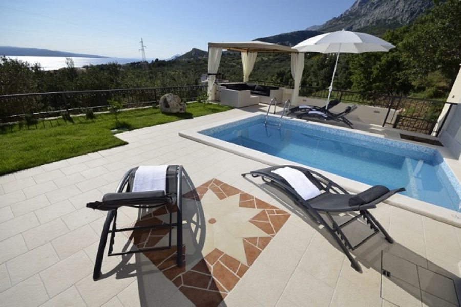 Pool with sun lounges at villa Majda