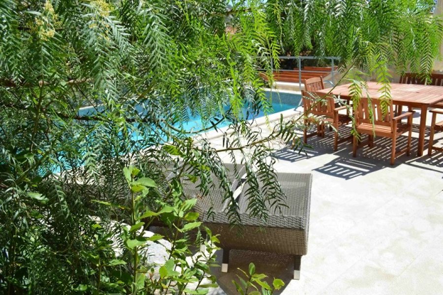 Sun lounges, dining table and chairs at the pool